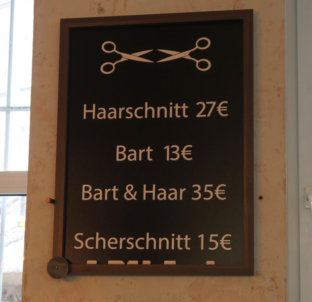 Preisschild mit zwei Scheren, Harrschnitt 27 Euro, Bart 13 Euro, Bart und Haar 35 Euro,  Scherschnitt 15 Euro